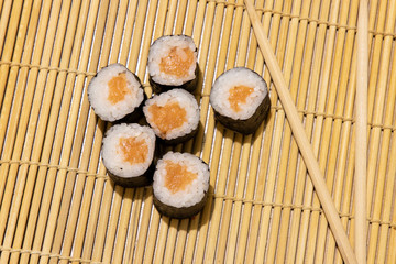 maki sushi rolls with raw salmon fish food photography concept wooden carpet background table surface
