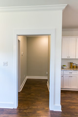 open hallway to bedrooms with a white kitchen in a new construction house