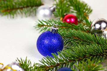 New Year and Christmas decoration with green fir tree branches and blue and silver shiny xmas traditional balls and baubles for greeting invitation cards.