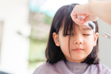 Asian Mother cutting hair to her daughter by herself at home.Stay at home stay safe from Covid-19...