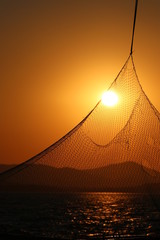 sunset behind a fishing net