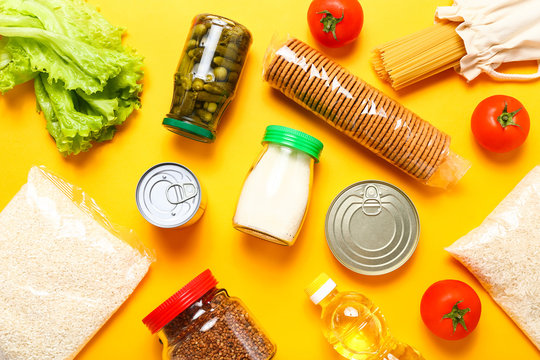 Food supplies for the period of quarantine on yellow background. Set of grocery items from canned food, vegetables, pasta, cereal. Food delivery concept. Donation concept. Top view.