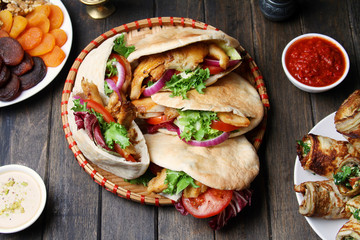Chicken Shawarma In Pita Aish With Sauces Harissa And Tahini On Black Wooden Background. Top View, Flat Lay. Ramadan Food Concept.