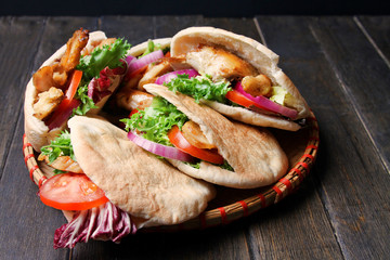 Chicken Shawarma In Pita Aish With Sauces Harissa And Tahini On Black Wooden Background. Top View,...