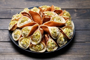 Qatayef With Cream And Pistachio On Plate On Black  Background. Side View, Close Up. Ramadan Food Concept.