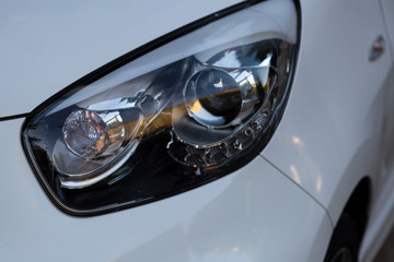 Clean headlights of white car. Close-up, headlight car Projector/LED of a modern luxury technology and auto detail