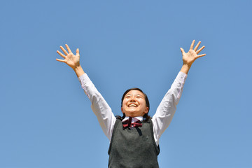 青空でバンザイする女の子