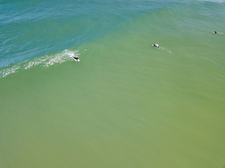 Surfers battle large waves near the shore of Island Beach State Park in New Jersey as they search for the ultimate wave seen from an aerial drone