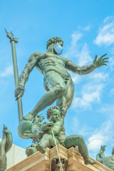 Fototapeta na wymiar Close up of Statue of Neptune with surgical mask, symbol of Bologna city during Covid-19 time. Italy and SARS-CoV-2 pandemic. Italian Coronavirus Quarantine.