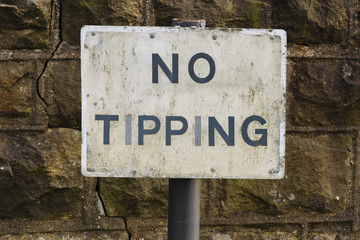 Dilapidated No Tipping sign warning people not to dump trash