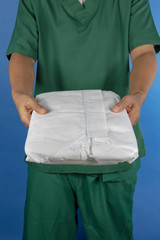 Medical staff offering a white cover all personal protective suit for covid-19 virus protection
