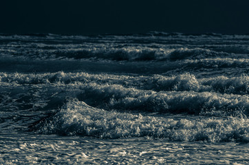Choppy incoming waves by moonlight