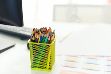Desk in office with computer and Color pencils or Crayons colored for designer desk Table working...