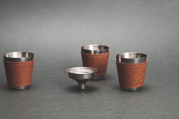 Metallic shot glasses and funnel. travel shot glass for alcohol with leather casing over the...