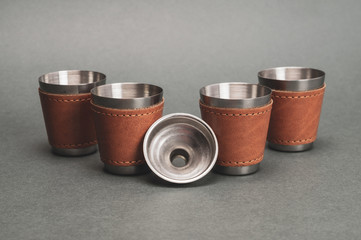 Metallic shot glasses with funnel. travel shot glass for alcohol with leather casing over the stainless steel