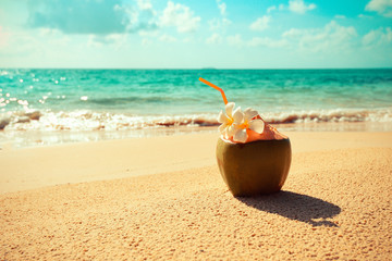 Fresh coconut juice summer with flower on beach sea in hot weather ocean landscape nature outdoor vacation , young coconut Coconut tropical fruit on sand beach background water