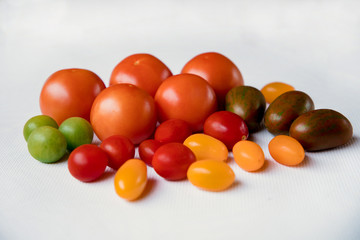 different types of tomatoes lie on a white background
