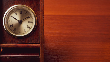 Retro wooden clock. square shaped vintage clock with round dial. wood table