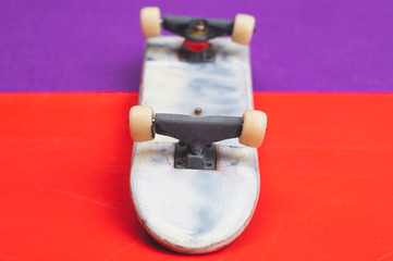 Small skateboard on color background. tiny skate for fingers. fingerboard close up