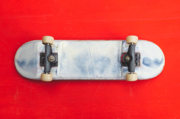 Small skateboard on red background. tiny skate for fingers. fingerboard close up