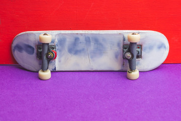 Small skateboard on color background. tiny skate for fingers. fingerboard close up