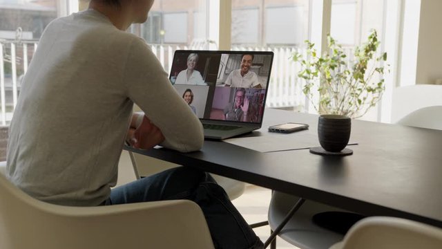 Woman having video call with family while working from home. Woman connecting with her family while at home via video conference.
