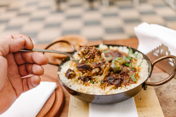 Person taking food from a paella with rice and beans