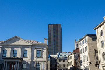 Typical panorama of Old Montreal, Quebec, Canada with historic stone houses and a skyline in background. Also called vieux Montreal, it is the oldest place of the city and a major touristic landmark.