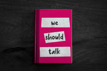 A pink book with a simple three worded message written on the front. 
