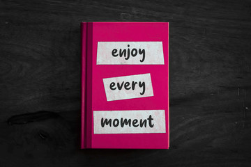 A pink book with a simple three worded message written on the front. 