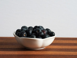 bowl of fresh blueberries on wood with with in background
