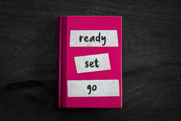 A pink book with a simple three worded message written on the front. 