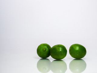three limes with reflections on white background