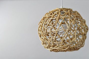 Wicker lamp made of natural materials hanging from the ceiling. Copy space. 