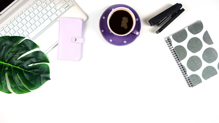 Desktop workspace flat lay with hi-tech touch screen laptop and modern purple, black and white accessories on white background. Negative copy space.