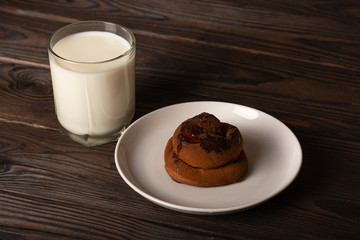 warm fragrant bun with cinnamon and a glass of milk. the breakfast is light. homemade baking