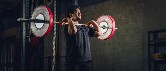 asian strong athletic man having workout and bodybuilding with barbells weight front squat setting...