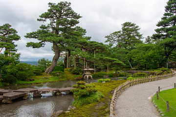 Fototapeta na wymiar Beautiful Japanese Garden in Kyoto, Japan with River and Lush Forest Tree Background 