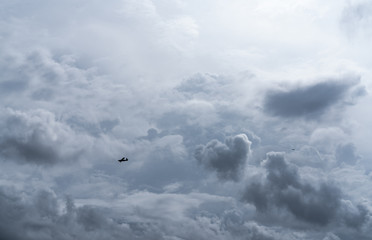 Small plane in cloudy sky for rainmaking. White fluffy clouds with small aircraft to make...