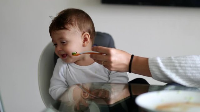 Baby Rejecting Food, Mother Trying To Feed One Year Old Infant Toddler