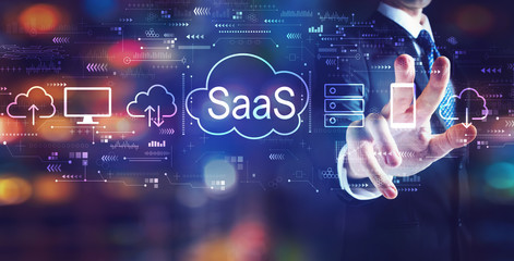 SaaS - software as a service concept with businessman on night city background