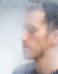 man behind the window while it rains
