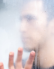 man behind the window while it rains
