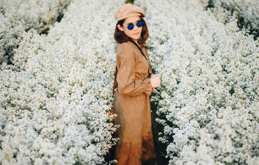 Portrait of young Asian tourist woman visiting cutter flowers field grows in Mae Rim district,...