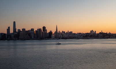 Fototapeta na wymiar Boat in front of San Francisco skyline at sunset