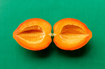 Cross section of a seedless ripe papaya on green background