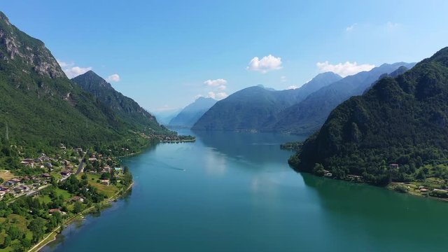 Panoramic view of the mountains and Lake Idro. Blue sky. Aerial view. Flight over the lake