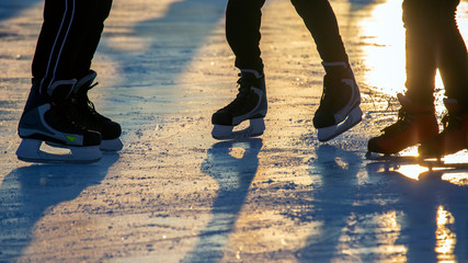 different people are actively skating on an ice rink. hobbies and leisure. winter sports