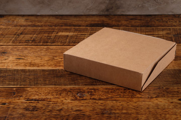Big brown paper box isolated on wooden background. Eco-friendly disposable food packaging. Preserving nature and recycling concept.Copy space.