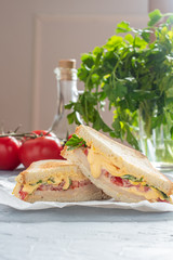 sandwich with cheese sauce, lettuce, tomato slice